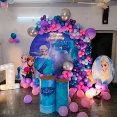 A complete Frozen-themed first birthday backdrop we designed for a magical celebration. This setup includes a custom circular backdrop featuring Elsa, a cascading balloon garland in purple and blue hues, and a large light-up number '1'.