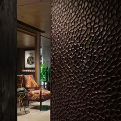 A close-up of a hand-scooped teak wood door from our Caitriona apartment project, showcasing the Japanese 'Shou Sugi Ban' finishing technique. This detail highlights our passion for materials and hands-on craftsmanship, where every texture is chosen with care.