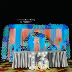 A grand stage decoration for a 13th birthday. This large-scale setup features a full balloon backdrop, a smaller inner arch, and light-up marquee numbers.