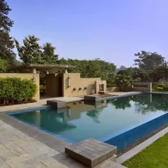 The pool area at C Farm is designed with clean lines and natural materials. Stone decking and integrated planters create a seamless transition from the water to the lawn, while a feature wall adds architectural interest and privacy.