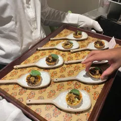 Service in style. White-gloved hands present a tray of intricate canapés, showcasing the level of elegance I bring to my private dining events.