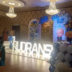 Here is the final look of the Boss Baby theme for Rudransh's birthday. The stage is lit up with large marquee letters, a neon "Happy Birthday" sign, and a shimmery gold backdrop.