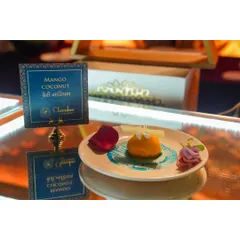 A tropical delight. This Mango Coconut dessert is a refreshing and beautifully plated sweet, reflecting a fusion of flavors with a nod to local tastes, as seen on the Gujarati menu sign.