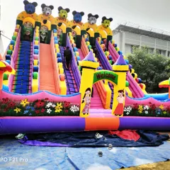 A look at our grand 6-slider bouncy castle, measuring 26 by 30 feet. This model is perfect for handling large crowds at fairs and amusement parks, with multiple climbing lanes and slides topped with cartoon bear figures.