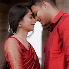 An intimate close-up of a couple, their noses touching and eyes closed in a moment of pure connection. The red outfits add a touch of passion.