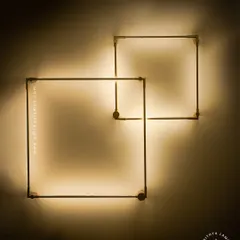A closer look at our minimalist square LED wall sconces. The slim gold-finished frame emits a soft backlight, creating a halo effect on the wall. These can be arranged in overlapping patterns for a custom art installation.