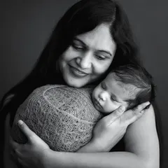 There is nothing like a mother's embrace. This classic black and white portrait of a mother holding her sleeping newborn close to her heart is so pure and emotional. These are the moments that pass by in a flash.