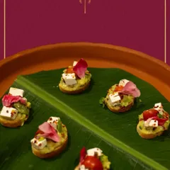 An array of our avocado and paneer crostini, beautifully arranged on a banana leaf. The edible flower garnish adds a touch of elegance, making it a feast for the eyes.