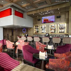 The inviting interior of Neptune Bar & Lounge, with its plush, colorful seating and fully stocked bar, creates a sophisticated atmosphere for our guests.