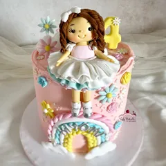 Somewhere over the rainbow! A sweet cake with a custom doll topper, a pastel rainbow, and delicate flowers.