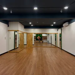 A full view of our spacious yoga hall. The open layout and mirrored walls provide the perfect environment for group classes, ensuring everyone has the space and visibility to practice safely.