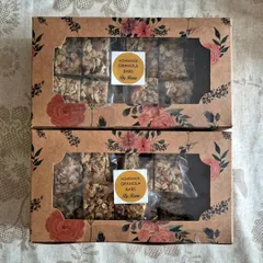 Two gift boxes of my homemade Granola Bars. These energy bars are packed with rolled oats, nuts, seeds, and dried fruits, making them a perfect healthy snack.