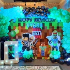 A Minecraft-themed 10th birthday party. We used a pixelated backdrop, life-sized character cutouts from the game, and a green and black balloon arch to recreate the world of Minecraft.