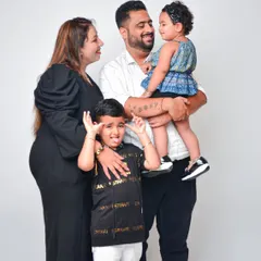 A fun and candid family photo that captures the real-life energy of a family with young children. We love these unposed moments that show off everyone's playful side.