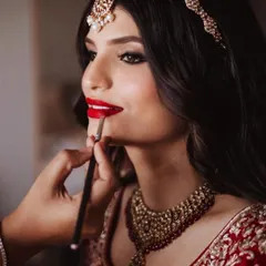 The final touch for a classic bridal look. A perfectly defined red lip is timeless. Here, I'm using a brush for precise application, ensuring the color is rich and lasts through all the wedding day emotions.