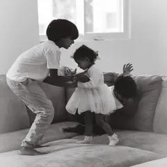 Family life is beautifully chaotic. This candid shot captures the playful energy of siblings interacting at home, showcasing the honest, unposed style of my black and white family photography.