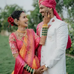 A laugh that lights up the frame. This candid photo captures a moment of pure joy, highlighting the bride's intricate jewelry and the couple's easy chemistry.