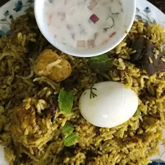 My Gongura Chicken Biryani is a tangy and spicy delight. The unique flavor of gongura (sorrel leaves) is infused into the tender chicken and rice, served here with a cooling raita.