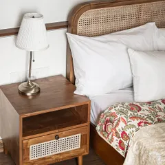 This bedroom setting features my teak bed with a woven rattan headboard, paired with a matching side table. The side table includes an open shelf and a drawer with a rattan front for concealed storage.