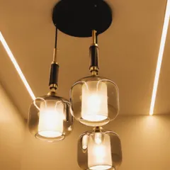 A close-up of elegant pendant lights with smoked glass and brass details, casting a warm and sophisticated glow.