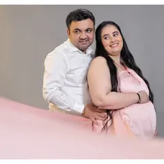 A happy and relaxed couple's portrait in the studio. The flowing pink fabric in the foreground adds a soft, dreamy touch to the photo.