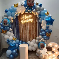 This Boss Baby themed decoration is perfect for a stylish toddler's birthday. It includes a circular balloon arch in blue, white, and silver, a "Happy Birthday" neon sign, Boss Baby character foil balloons, and a light-up marquee number '3'.