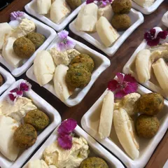 A classic party starter, our falafel and pita bites. We serve our freshly fried falafel with creamy hummus and soft mini pita bread, garnished with edible flowers for a beautiful touch.