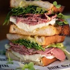 Meet our stacked pastrami sandwich. We pile tender pastrami, our fresh, handmade mozzarella, and crisp greens between slices of our naturally leavened sourdough. It’s a full meal and a testament to our love for big, bold flavors.