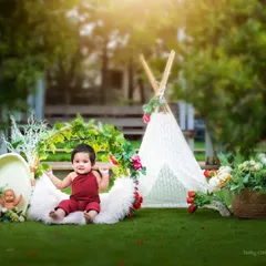 This wide shot shows the full boho setup for an outdoor session, complete with a lace teepee, floral arrangements, and soft textures for the baby to sit on.