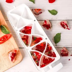 A beautiful shot of DIY ice cubes made with rose petals and basil. The bright, clean styling is perfect for beauty and wellness content.