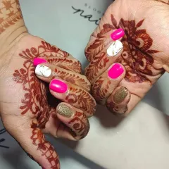 I am obsessed with creating the perfect bridal nails. This set features vibrant pink, gold glitter, and a white marble accent nail, all designed to complement the beautiful wedding mehendi.
