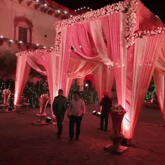 An enchanting entrance we designed for a wedding at Tijara Fort Palace in Alwar. We used flowing pink and white drapes complemented by lush floral arrangements to create a grand welcome that respects the heritage of the venue.