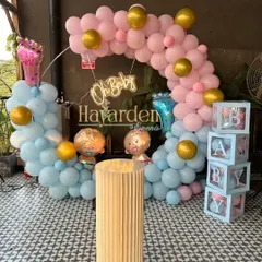A 'He or She' themed baby shower decor. This setup features a circular balloon frame in pink and blue, 'BABY' blocks, and an 'Oh Baby' neon sign.