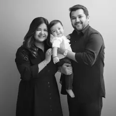 A picture-perfect family of three, smiling warmly for the camera. These simple, elegant portraits are a treasure.