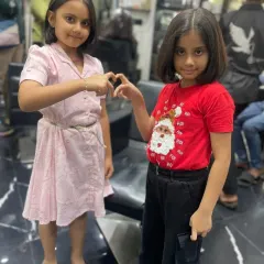 Another adorable shot of these two sisters with their fresh haircuts. I make sure every child leaves my salon feeling happy and confident with their new look.