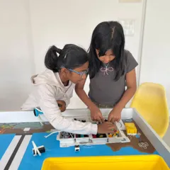 Collaboration is crucial for success. Two students work together on their robot for the Indian Robotics Olympiad, combining their building and programming skills to solve the challenge.