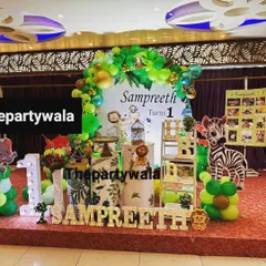 A full stage setup for a jungle safari first birthday. The large backdrop, light-up name, and photo milestone board make it a complete and memorable display.