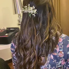 A simple yet beautiful half-up hairstyle with soft curls. I added a small sprig of baby's breath for a touch of romantic elegance.