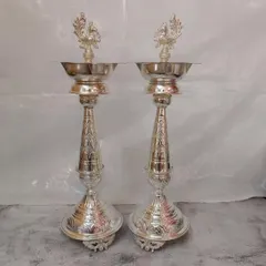 A pair of my grand 20-inch German silver Nakashi vilakku. These are designed to be statement pieces, bringing a majestic glow to your home during festivals and celebrations.