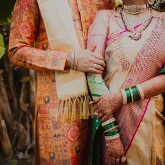 A quiet moment together amidst the greenery. This portrait focuses on the details of their Maharashtrian wedding attire and the gentle connection as they hold hands, ready to begin their new life.
