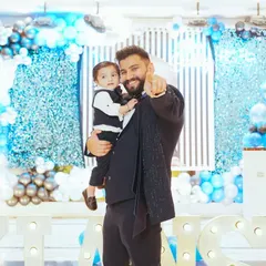 Father and son moments are truly special. This is a candid portrait of the birthday boy with his dad, sharing a happy moment in front of the vibrant party decorations.