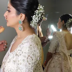 A profile view of the bride with her baby's breath bun, showing how it pairs with her elegant jewellery and outfit.