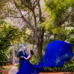 A candid moment of a couple dancing in a garden path. The motion of the flowing dress and the natural, happy expressions make this a lively and romantic image from their pre-wedding shoot.