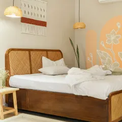 In our Goan project, Unallome, we embraced the philosophy of "susegad" or slow living. This bedroom is a testament to that, using a simple palette of natural materials like cane and wood, complemented by a hand-painted mural. It is a serene retreat designed for rest and connection.