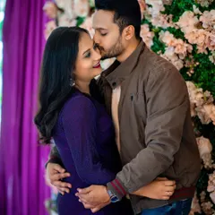 An intimate and happy moment between a couple during their pre-wedding photoshoot. The floral background adds a touch of romance and softness to the portrait.