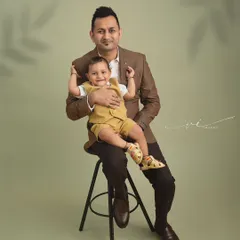 A proud father with his little boy. This classic father-child portrait captures a quiet moment of connection, showcasing their bond in a timeless studio setting.