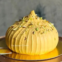 My 3D Modak Cake, a modern tribute to a traditional favorite for Ganesh Chaturthi. It's a cake shaped like a modak and frosted with saffron-infused cream and pistachios.