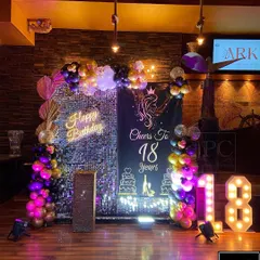 The full party setup for an 18th birthday, complete with dramatic lighting. The combination of dark, moody colors with sparkling and glowing elements creates a sophisticated and fun party vibe.