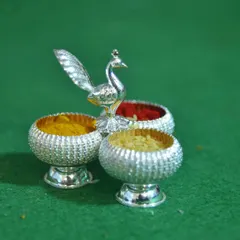 Detail shot of the silver kumkuma and turmeric holders (arishina kumkuma) essential for Hindu rituals. Capturing these small, significant items is part of telling the complete story of the event.