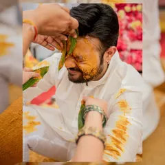 A close-up of the groom wincing playfully as turmeric paste is applied to his face during the Haldi ritual.